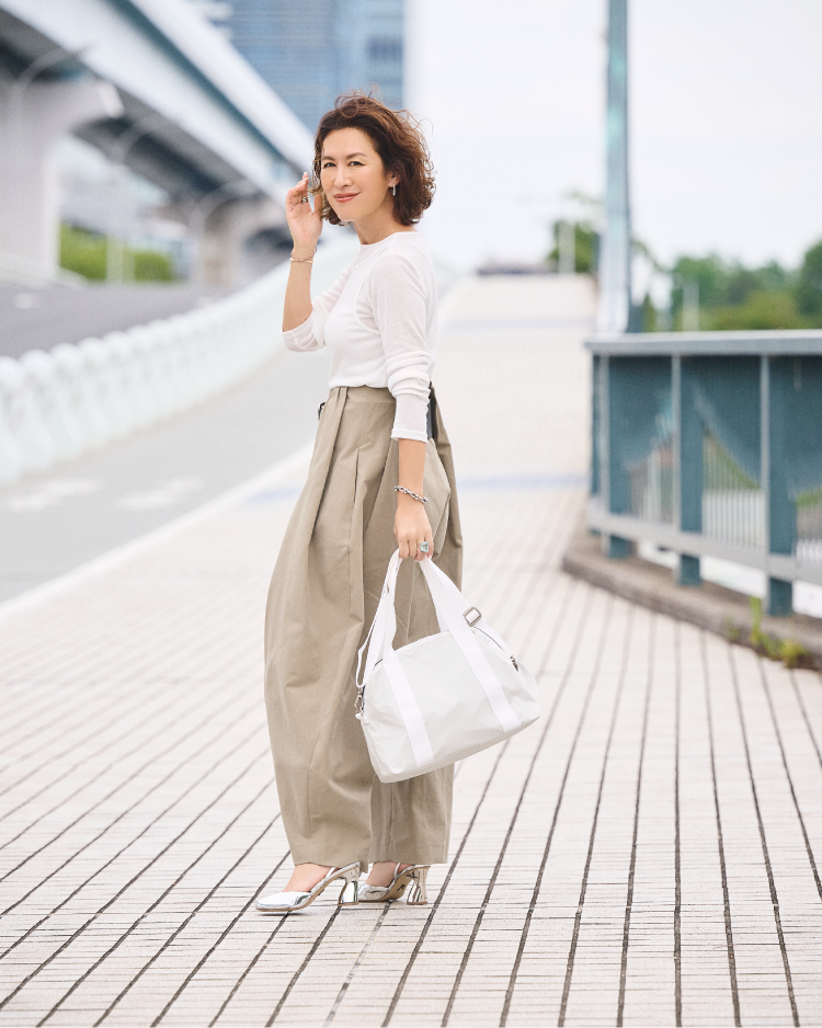 モダンフラップバックパックを背負い、デニムスタイルで振り返る女性