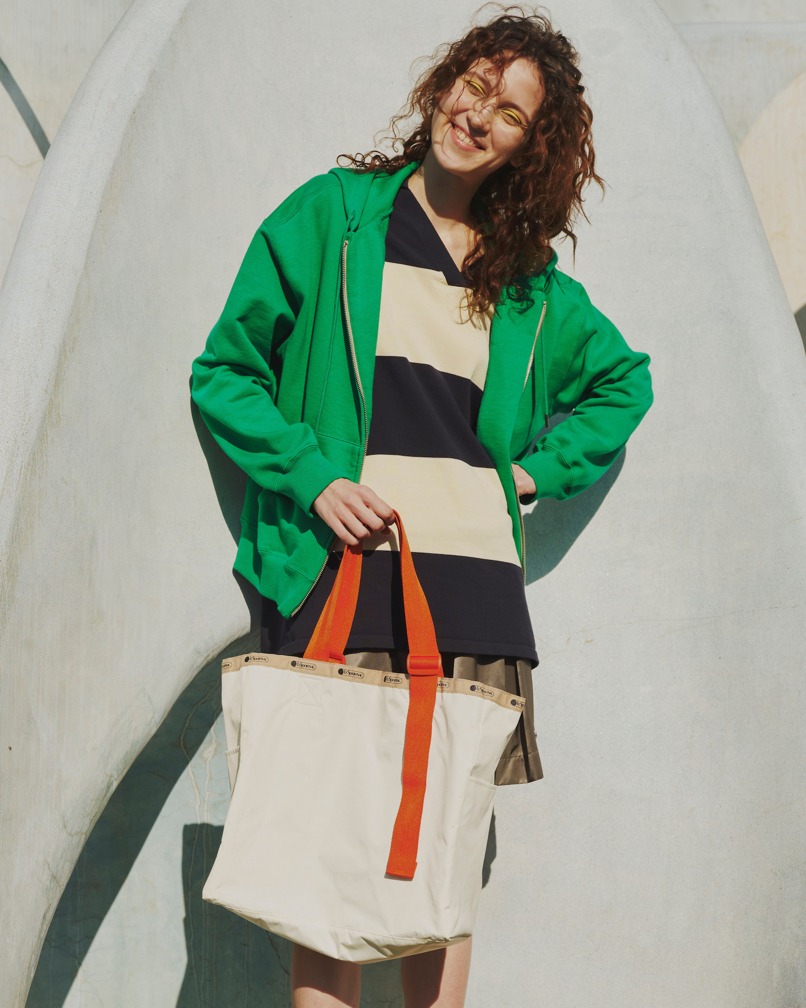 LG HANDLE ADJ TOTE メレンゲ/マンダリンウェビングを持った女性モデルの画像